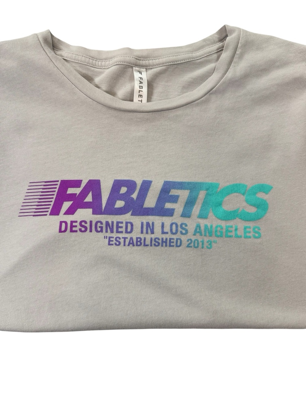 Fabletics Light Gray Tee with Purple-to-Teal Gradient Logo